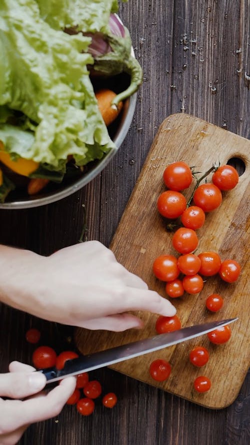 칼을 사용하여 체리 토마토를 자르는 사람의 상위 뷰