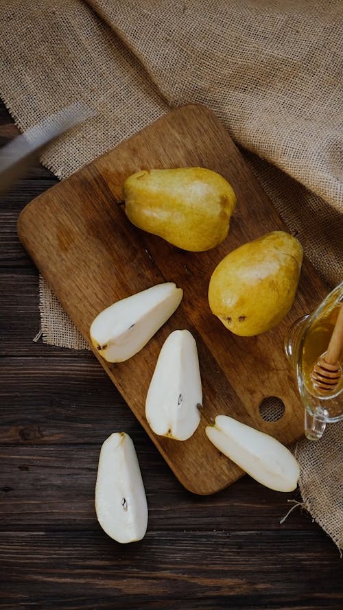 A Person Slicing a Pear Using a Knife