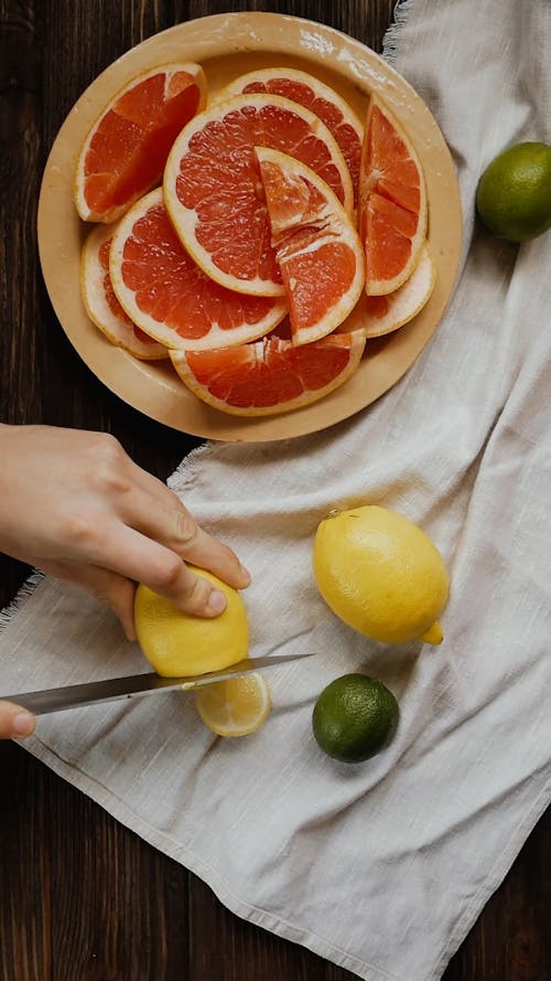 Seseorang Memotong Lemon Menjadi Irisan Menggunakan Pisau