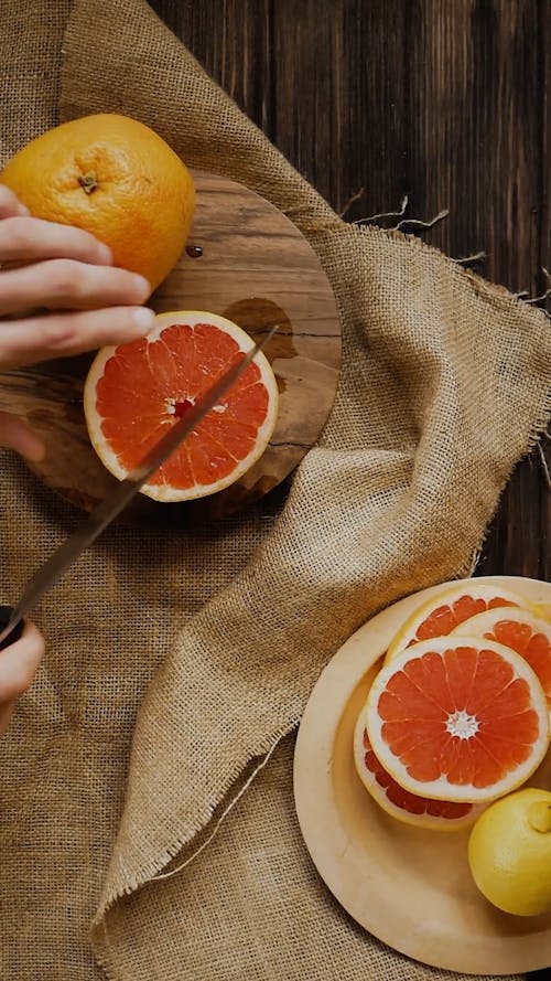 Een Persoon Die Een Grapefruit In Plakjes Snijdt Met Een Mes