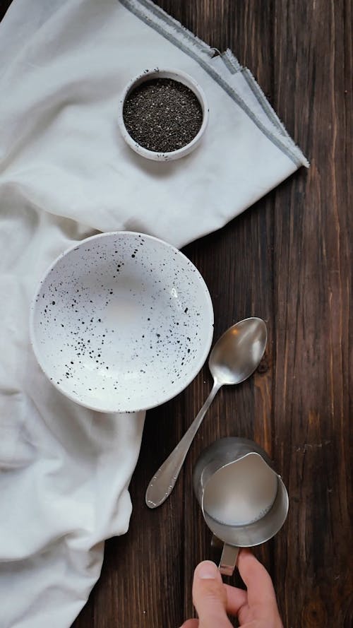 A Person Pouring a Milk in a Bowl