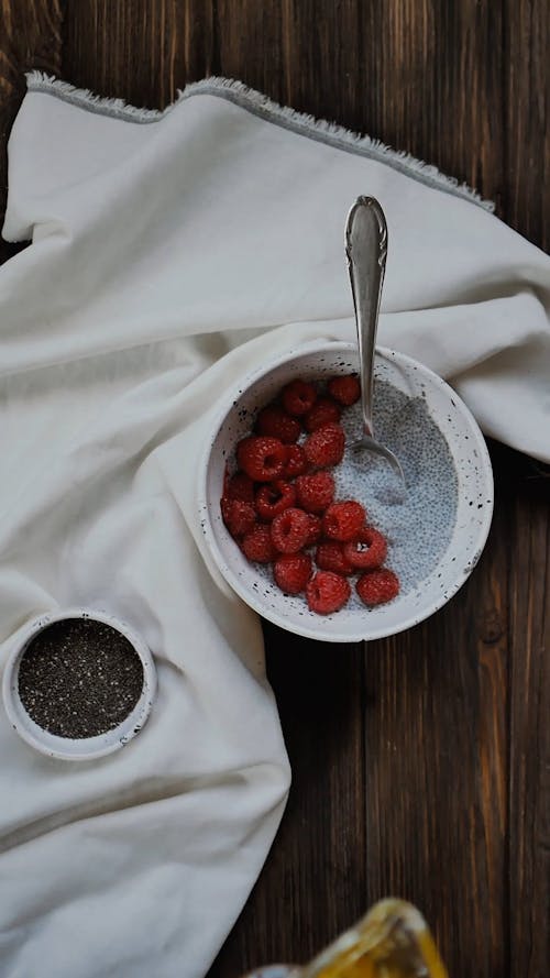 Menuangkan Madu Dengan Gerimis Kayu Di Atas Raspberry Dengan Susu Dalam Mangkuk