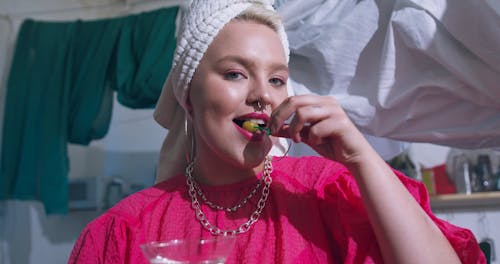 Woman Eating While Looking at the Camera