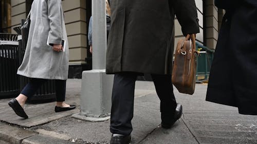 Three People Walking on Sidewalk