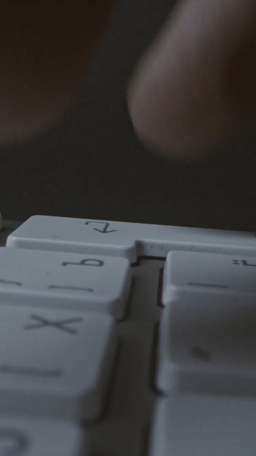 Close-Up View of a Person's Fingers Using an Apple Keyboard for Typing