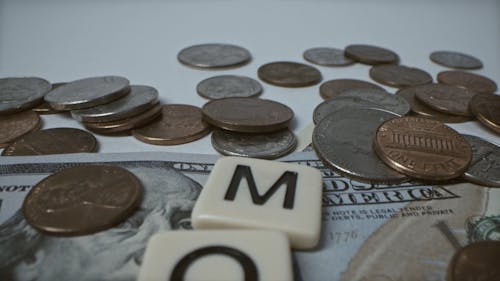Flat lay of Currency Notes Scrabble Tiles and Coins