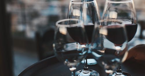 A Person Serving Wine Glasses on a Serving Tray