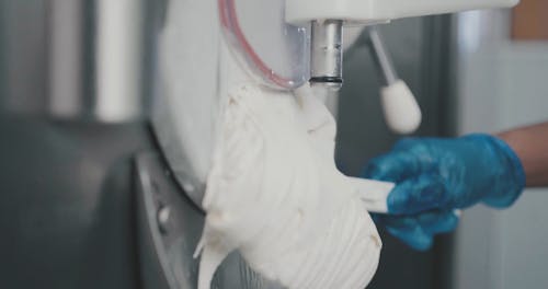 Person Collecting Ice Cream from Ice Cream Maker