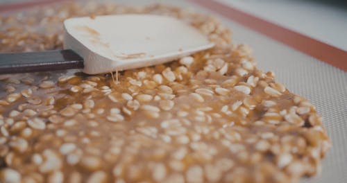 Person Making a Caramel Peanut Dessert