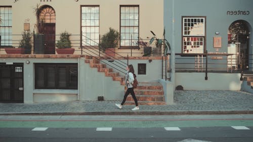 A Woman Walking on a Sidewalk