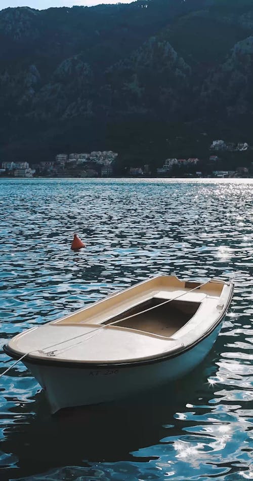 A Wooden Boat Tied To A Mooring Buoy