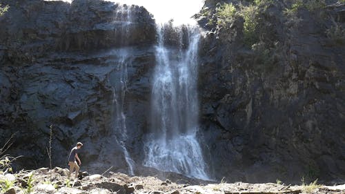 Man in front of a Waterfall