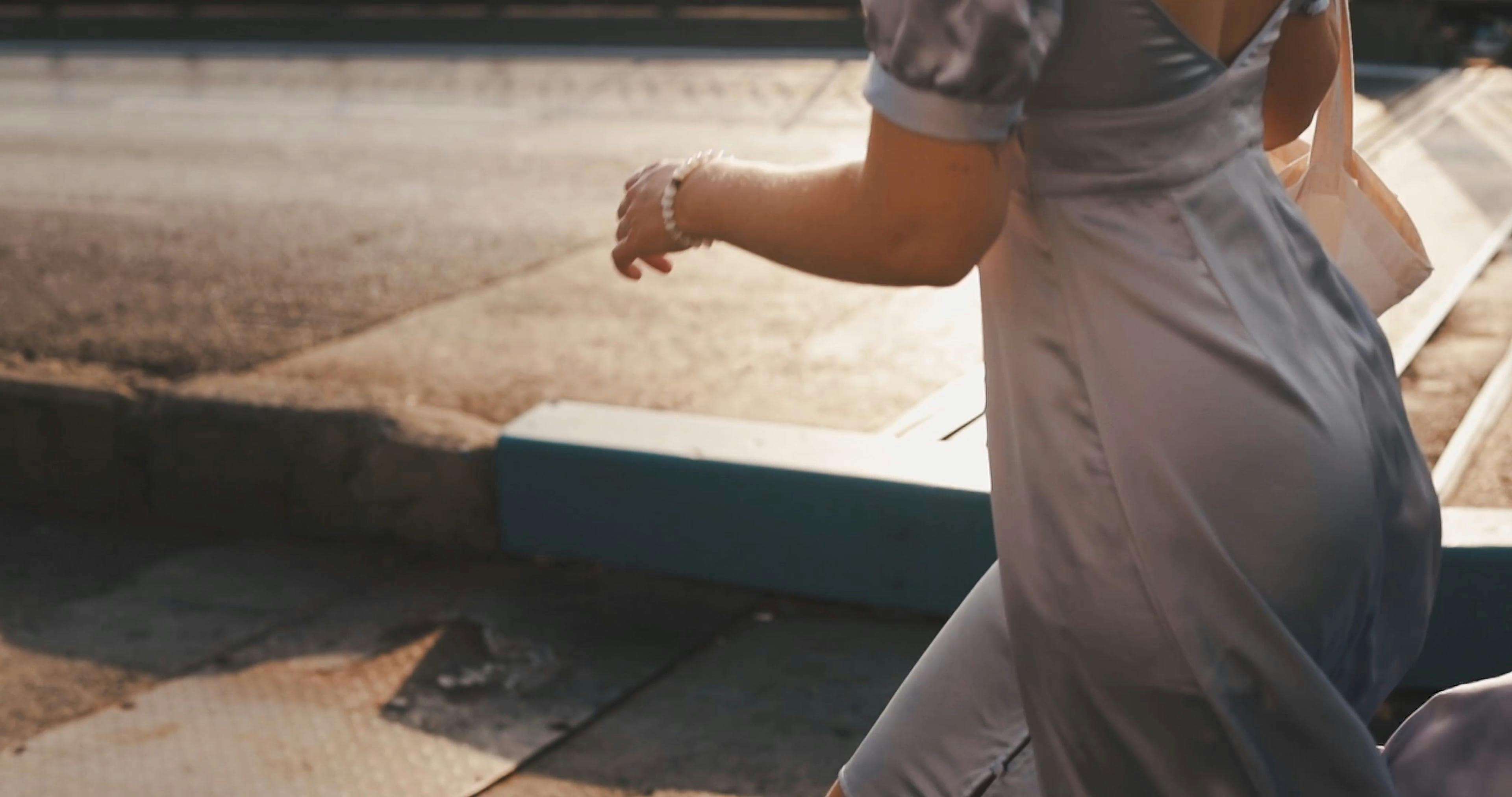 A Woman In Silver Dress Running In The Sidewalk · Free Stock Video