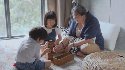 Kids Playing a Jenga Blocks with Their Grandma