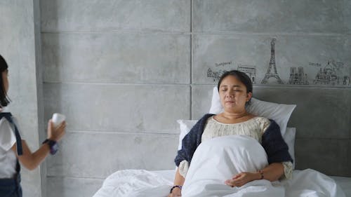 Girl Giving Medicine to her Mother