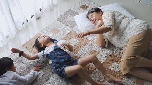 Girl Talking to a Woman While Lying Down on a Carpet