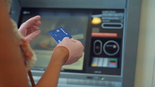 Woman Inserting Card on a Machine