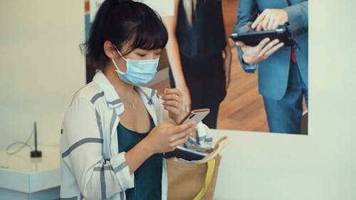 Girl Taking Off Her Mask Using the Phone 