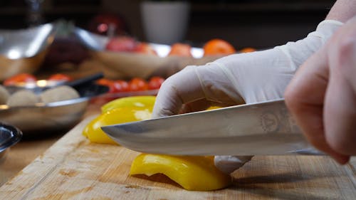Person Slicing a Yellow Bell Pepper