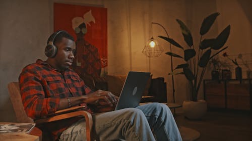 Young Man with Headphones Using Laptop  