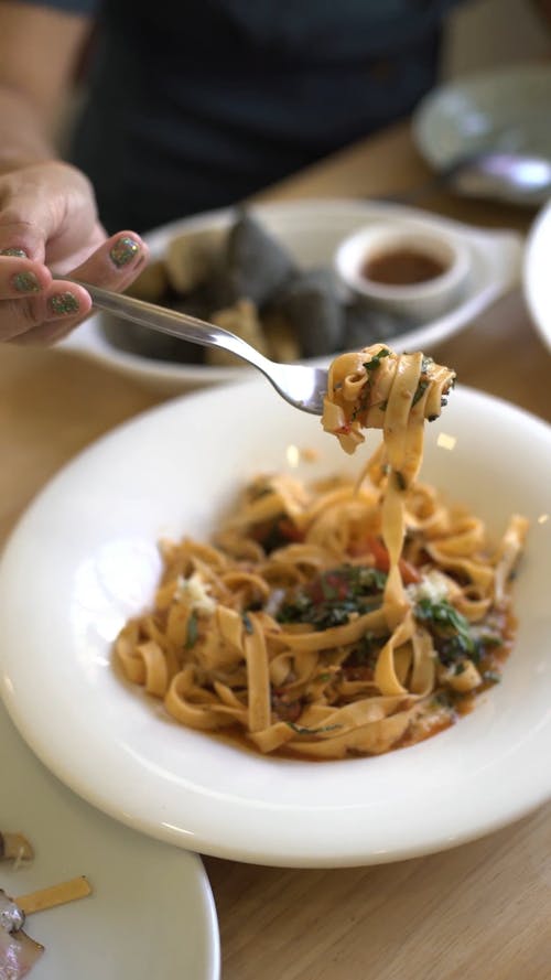 Cheerful Woman in a Restaurant Eating Ramens