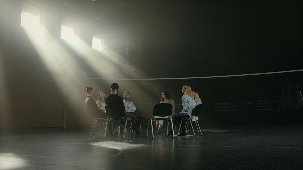 A small group in conversation in a sunlit room