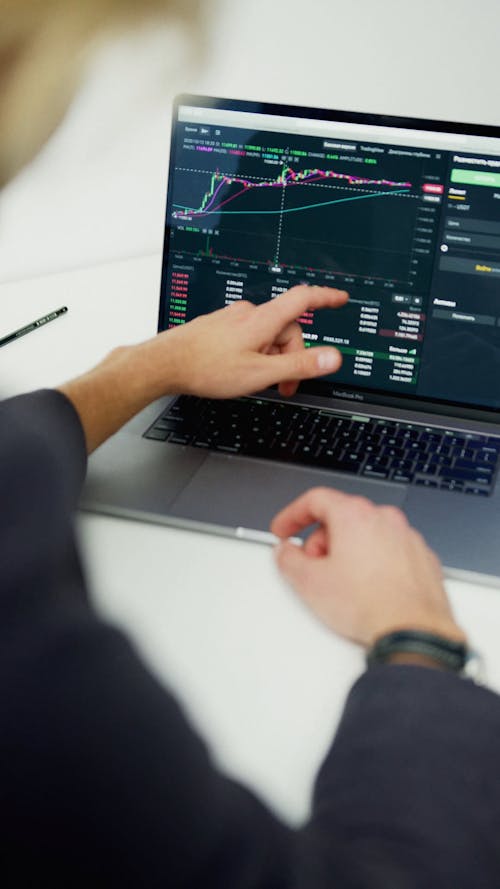 Woman Looking into Stock Market Fluctuations on laptop