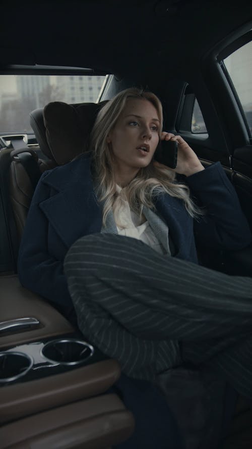A Woman Sitting In A Car Backseat With Legs Crossed 