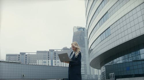 A Woman Using A Laptop While Standing