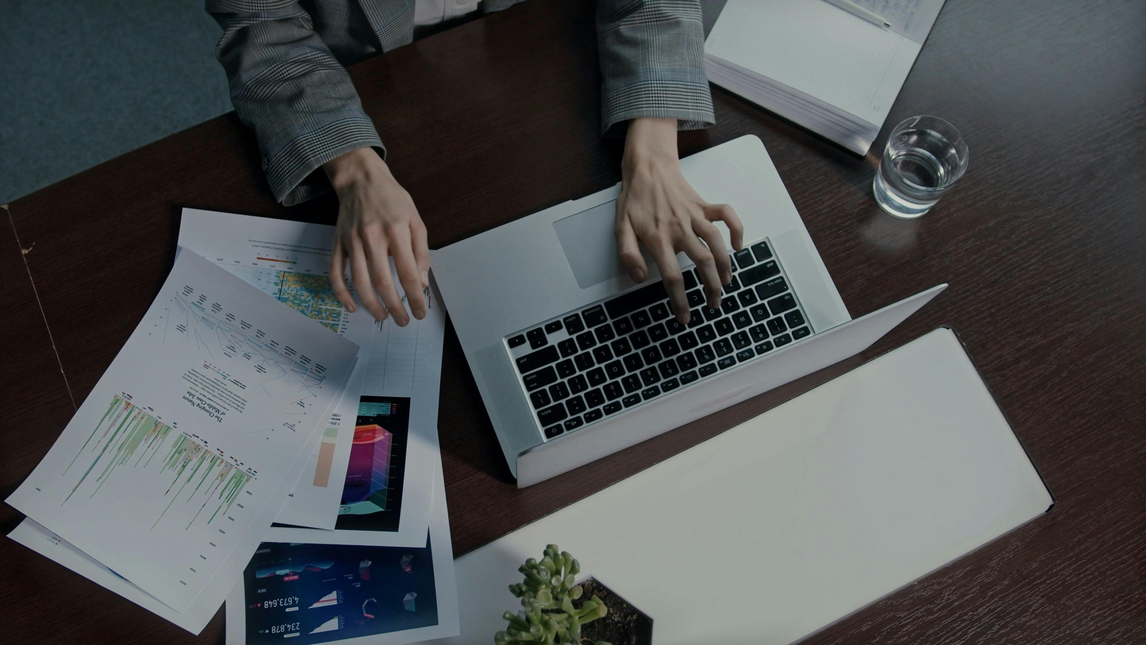 A Woman Looking At Graph While Working With A Laptop \u00b7 Free Stock Video