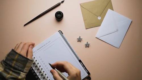 Close-Up View of a Person Writing Her New Year's Resolution