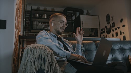 Young Man Sitting on Sofa Using Laptop