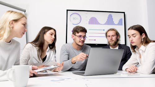 A Man is Showing and Discussing from the Laptop to his Colleagues