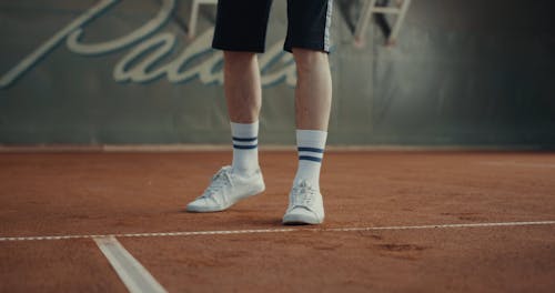 Caucasian Man Bouncing a Ball for Tennis Serve