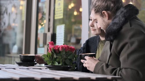 Couple Drinking Coffe with Red Roses Bouquet 