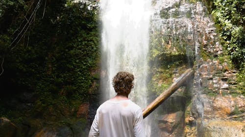 Man Taking Pictures of a Waterfall