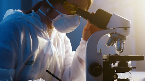 A Woman Looking Through the Microscope