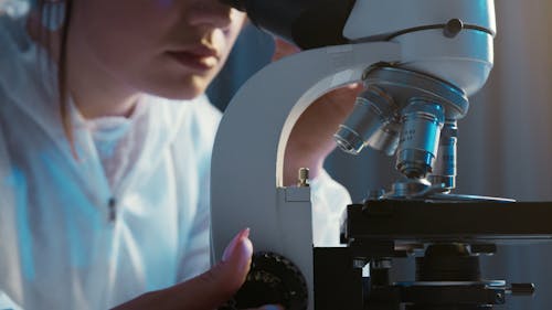Close-Up View of a Person Looking Through the Microscope