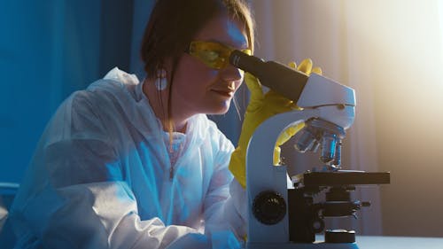 A Woman Looking Through the Microscope