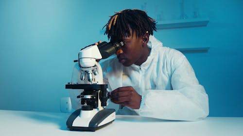 A Man Looking Through the Microscope