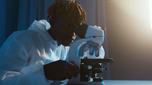A Man Looking Through the Microscope