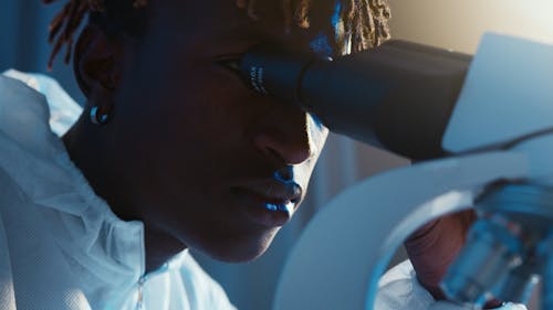 A Man Looking Through the Microscope