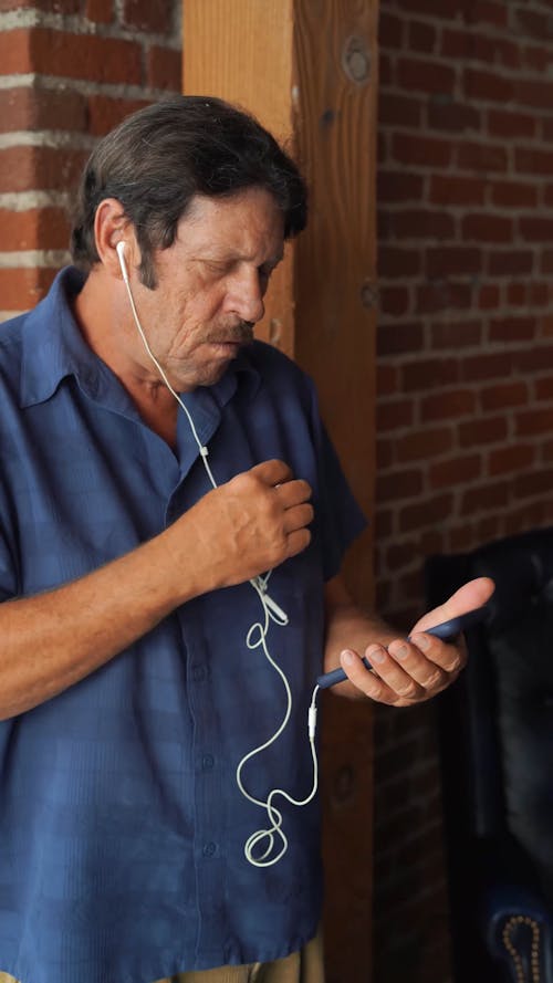 Man in Blue Polo Using His Smartphone