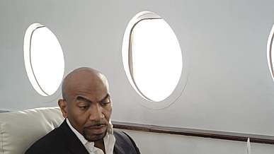 man reading a newspaper inside a jet