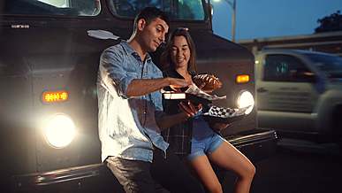 couple eating hot dog in a food truck