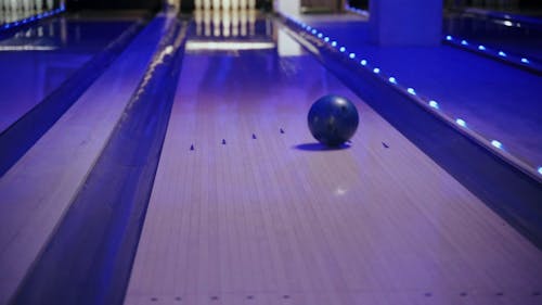 Rolling Bowling Ball in the Alley Striking the Bowling Pins