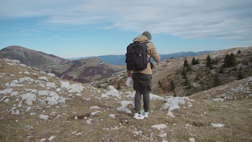 Man Looking at Cellphone While Hiking