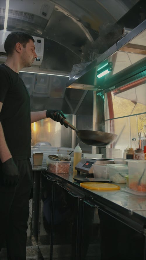 Vertical Video of a Man in Black T-Shirt Cooking in the Food Truck 