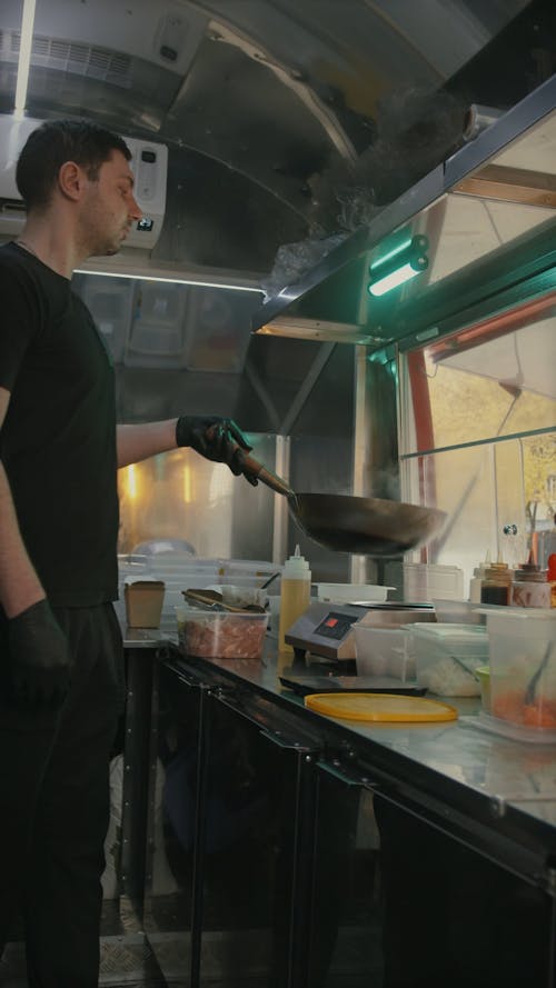 Vertical Video of a Man in Black T-Shirt Cooking in the Food Truck 