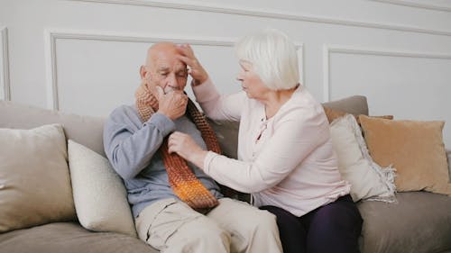 Man Coughing While Sitting on a Sofa